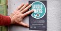 Audioways sign, person scanning QR code