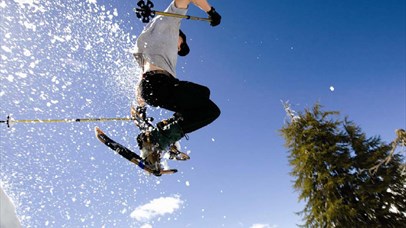 Person jumping with snowshoes and the snow is flying