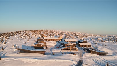 Winter view of Pellestova surrounded by snow-covered mountain landscape.