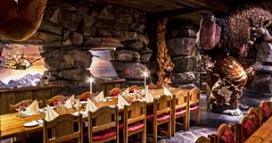 Dekkede bord i Trollsalen i Hunderfossen Eventyrpark der trollene holder taket oppe på skuldrene sine