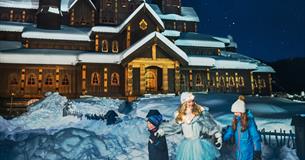 Prinsessa i Hunderfossen utenfor eventyrslottet med to barn i vinterparken