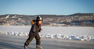 Kid ice skating on the lake Mjøsa