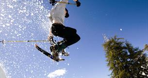 Person jumping with snowshoes and the snow is flying