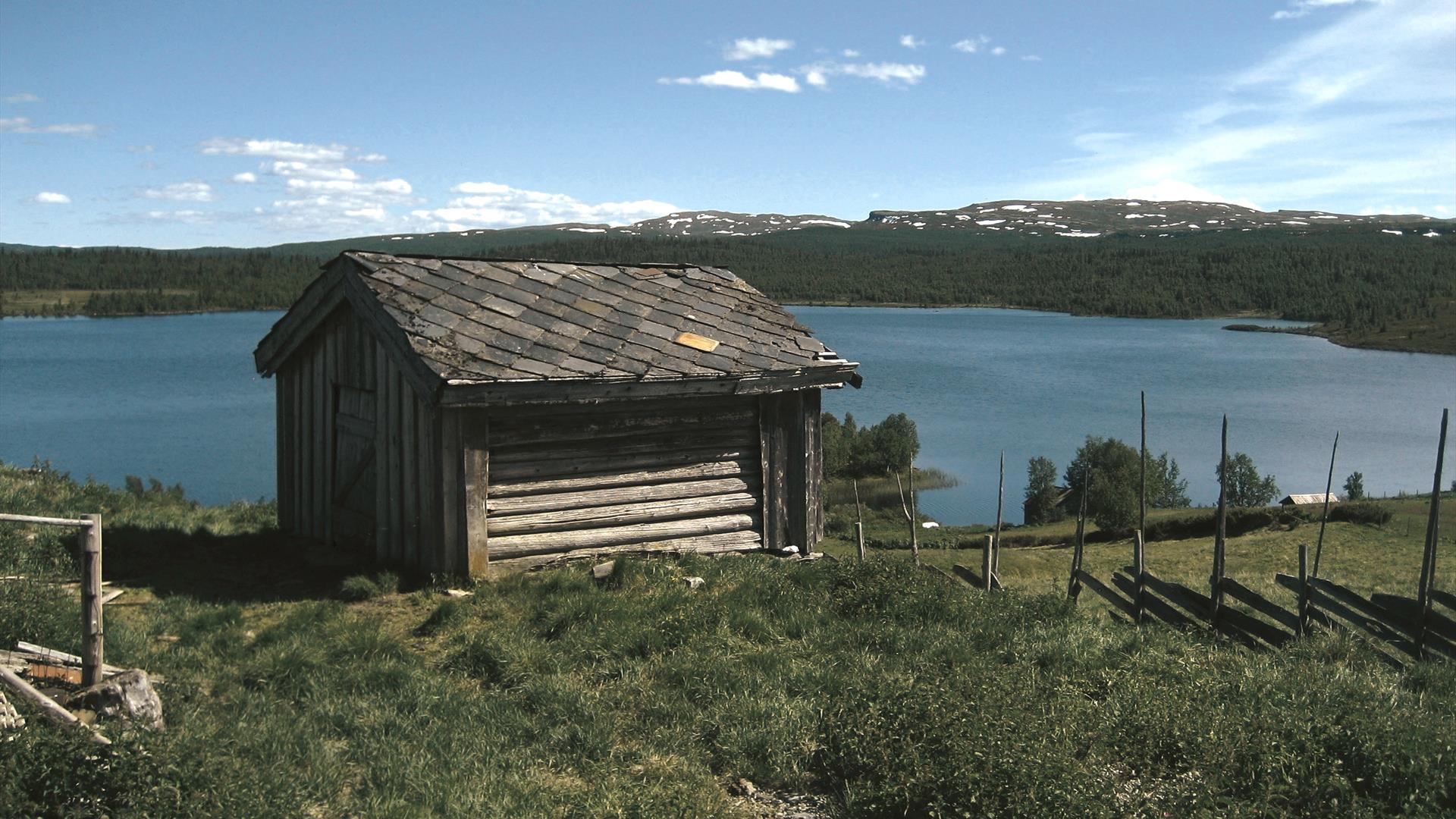 Lite hus ved fjellvann