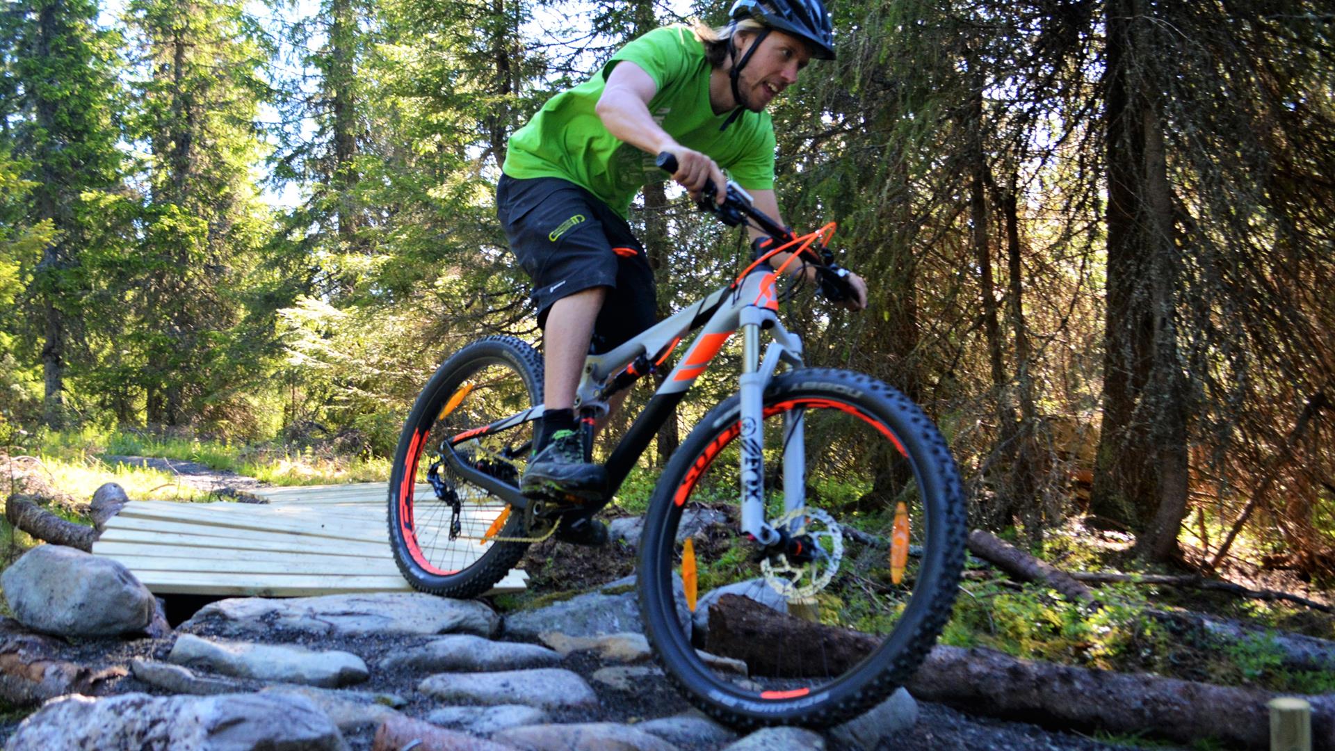 A man bicycling over some stones