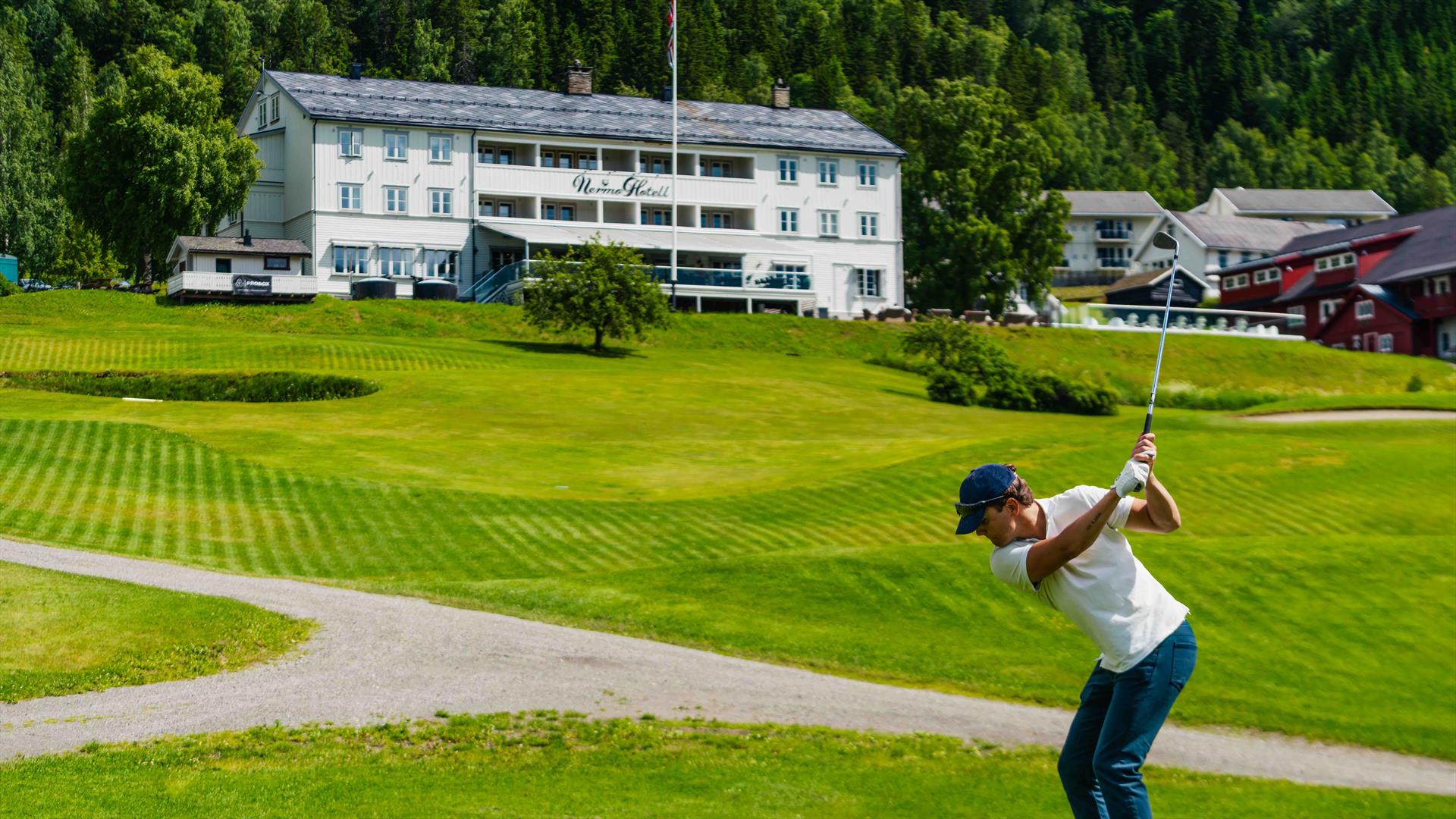 Golfer on a fairway near the clubhouse.
