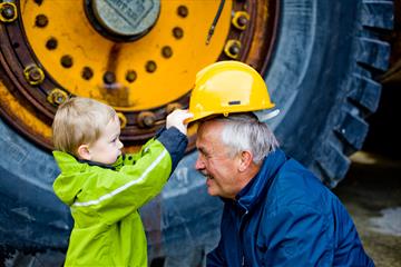 Gutt setter hjelmen på Bestefar hos Norsk Fjellsprengingsmuseum