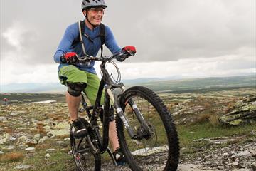 Mann auf einem Mountainbike, der aktiv einen Phad in der Skeikampen-Gegend radelt.