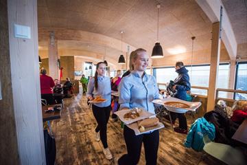 Waitresses on their way to serve delicious dishes to their guests at Skavlen