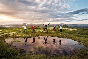 Group of hikers jumping by the water | Venabu Fjellhotell