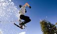 Person jumping with snowshoes and the snow is flying