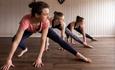 Three young women practice yoga