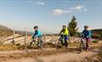 3 bicyclist cycling alongside a norwegian style fence called skigard