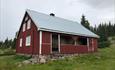 The red mountainfarm house on the Biskoplien mountain arm.