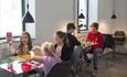 Kids and youths playing board games that are already integrated in the tabletop at Stasjonen Cafe & Restaurant