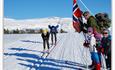 Glade tilskuere med norsk flagg