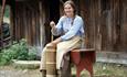 Mountain farm maid making butter.