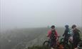 3 Mountainbiker mit Blick auf eine Schlucht im Venabygdsfjellet