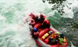 Rafting boat in powerful rapids viewed from above.