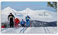 Deltagere staker i oppoverbakken, med majestestiske fjell i bakgrunnen - Kvamsfjellet