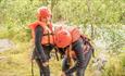 Participants with rafting gear by the riverside.