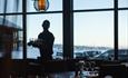 Waitstaff in a restaurant with large window views.