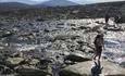 Hikers crossing running water up in the mountains | Venabu Fjellhotell