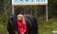 A young woman and a horse by the Venabu fjellhotell sign