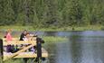 Father and 2 children fishing from a small pier.