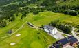 Aerial view of a golf course in a valley landscape.