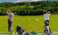 Golfers at a tee area.