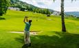 Golfer hitting a shot on the golf course.