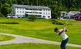 Golfer on a fairway near the clubhouse.