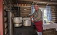 A woman, the ´budeia`, prepares food on a wood burning stove.