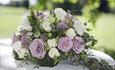 An arrangement of white and purple flowers on a white table cloth