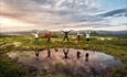 Group of hikers jumping by the water | Venabu Fjellhotell