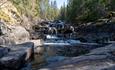 Liten foss og bekk i steinete terreng.