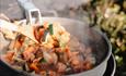 Food cooking in a pot over a fire