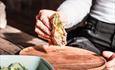 Hånd legger sandwich på fjøl