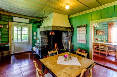 Kitchen at Sygaard Grytting with a fireplace in the corner