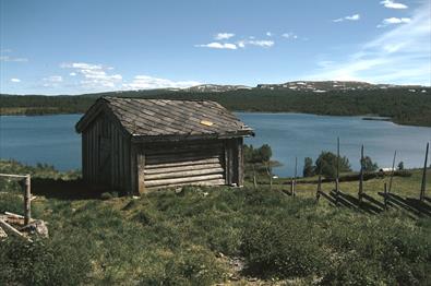 Lite hus ved fjellvann