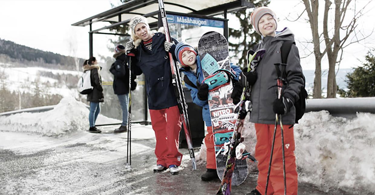 En familie venter på skibussen