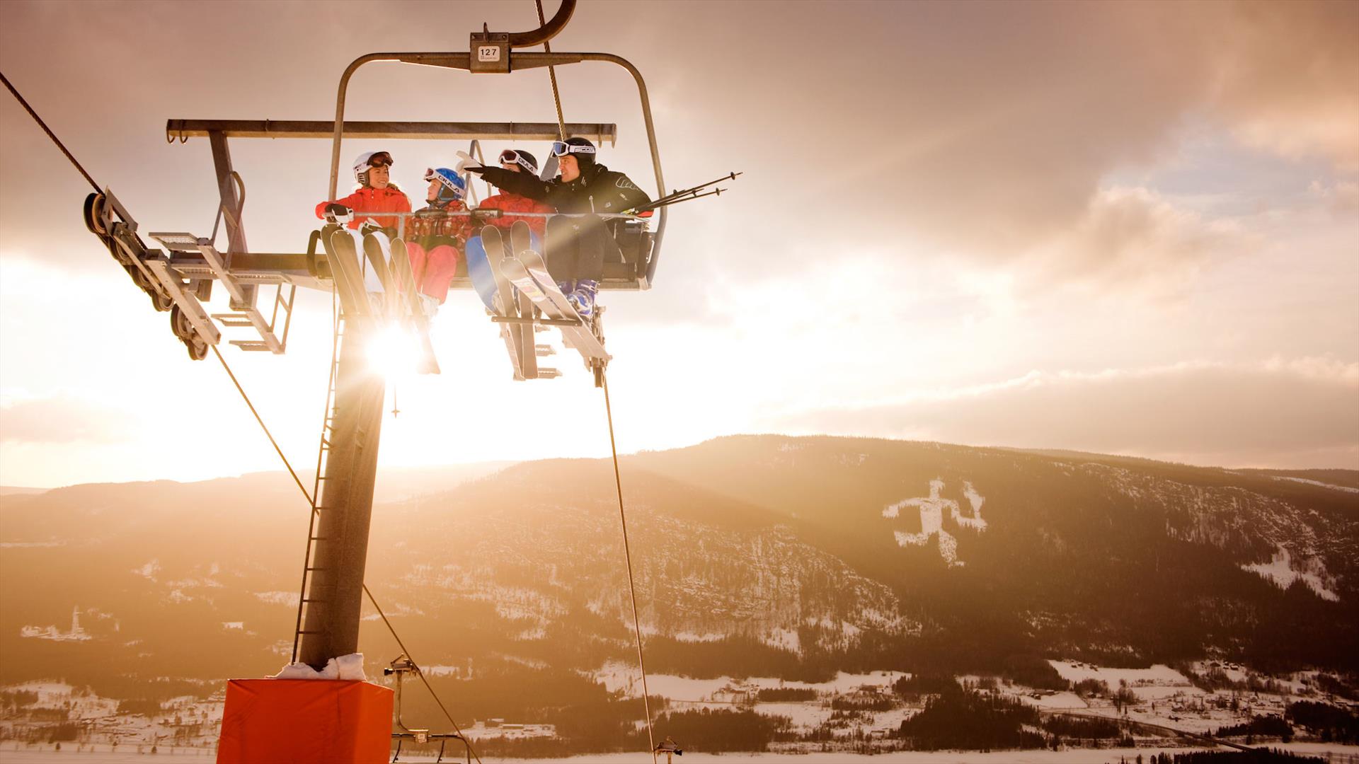 Alpine skiers in chairlift at Hafjell Alpine Resort