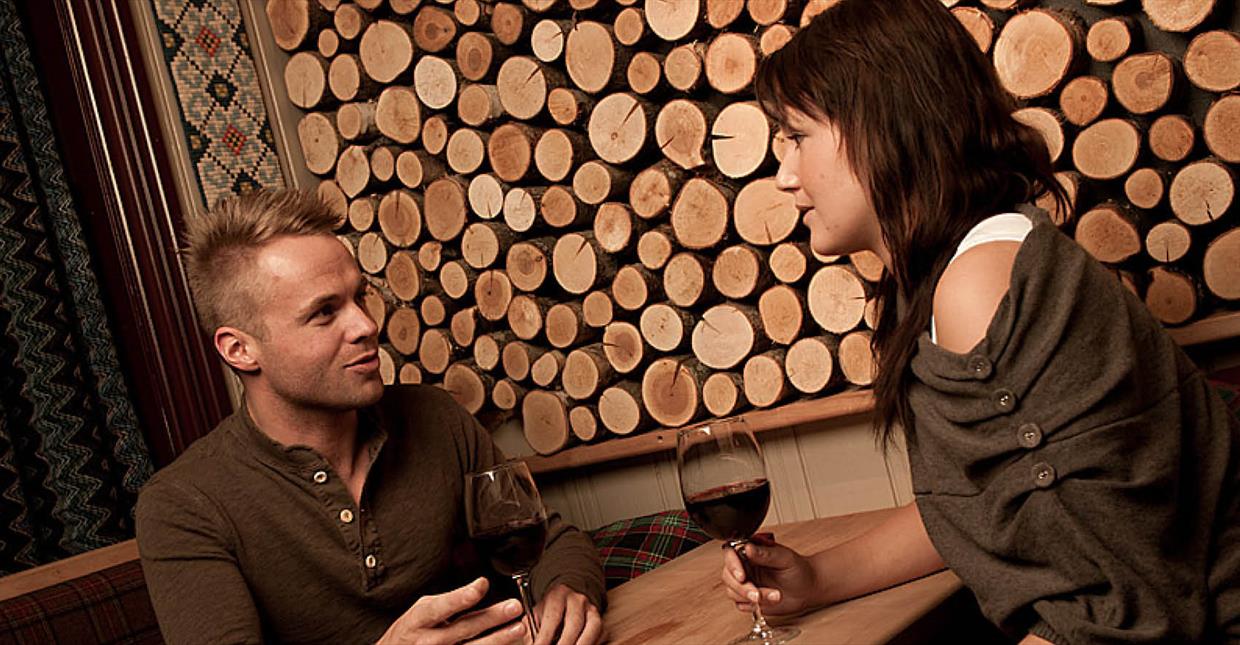 Et par som nyter et glass rødvin på Nikkers