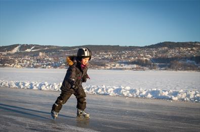 Kid ice skating on the lake Mjøsa