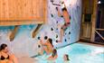 Climbing wall with people playing in and above water. Spidsbergseter Resort Rondane
