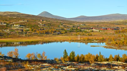 Overview of the area around the hotel with mirror lake, mountains and fall colors. Spidsbergseter Resort Rondane. 