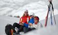 blide damer koser seg med appelsin og sjokolade på skitur