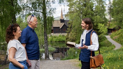 Museum visitors meeting an actor in front of Garmo stave church.