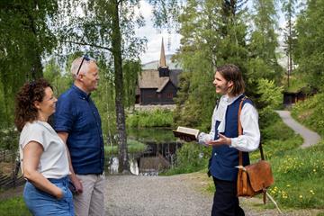 Museum visitors meeting an actor in front of Garmo stave church.
